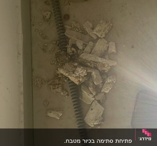 צינור גמיש עם שברי בטון על הרצפה